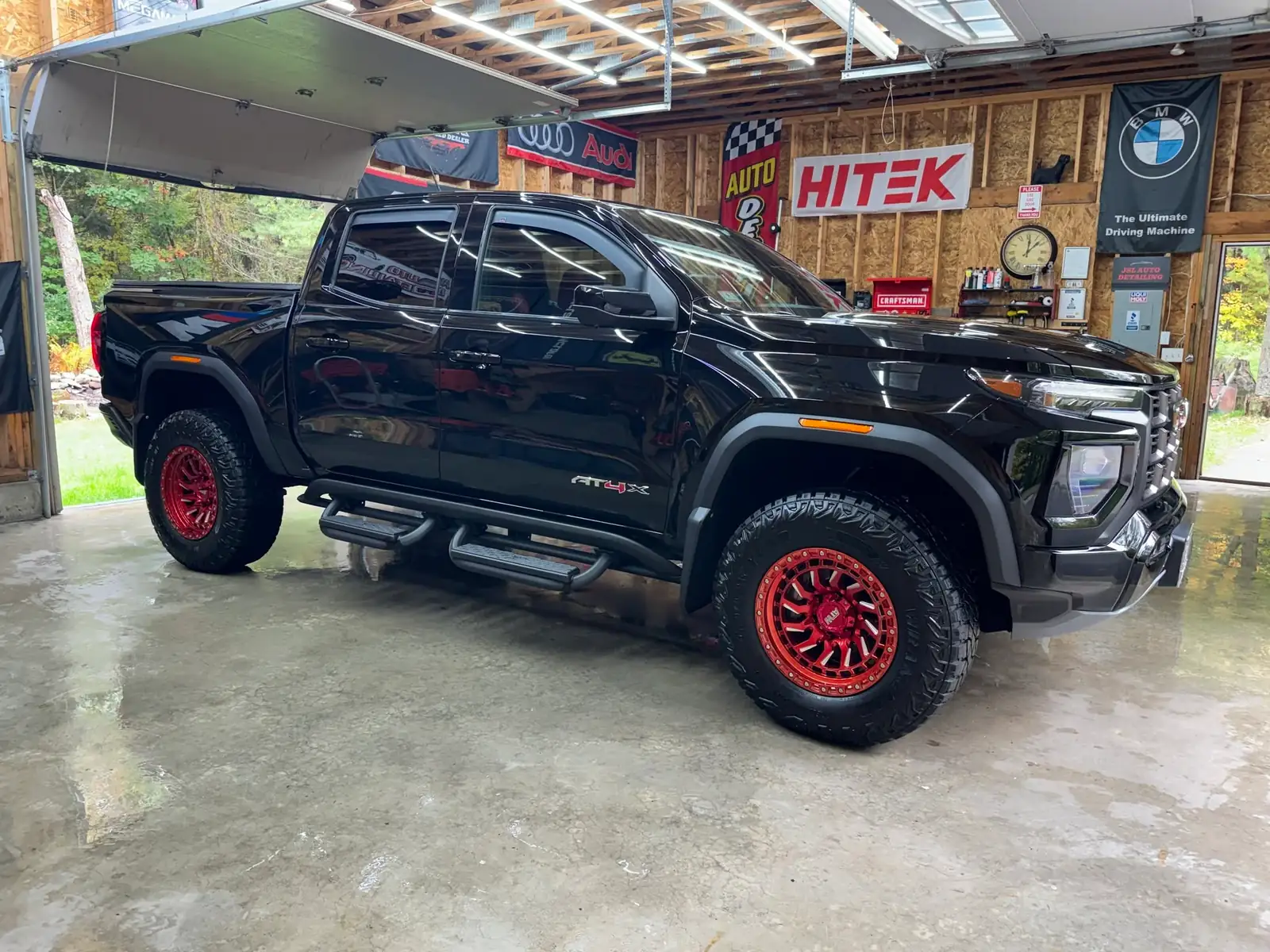 Black GMC Canyon AT4X with red wheels in Jason's shop