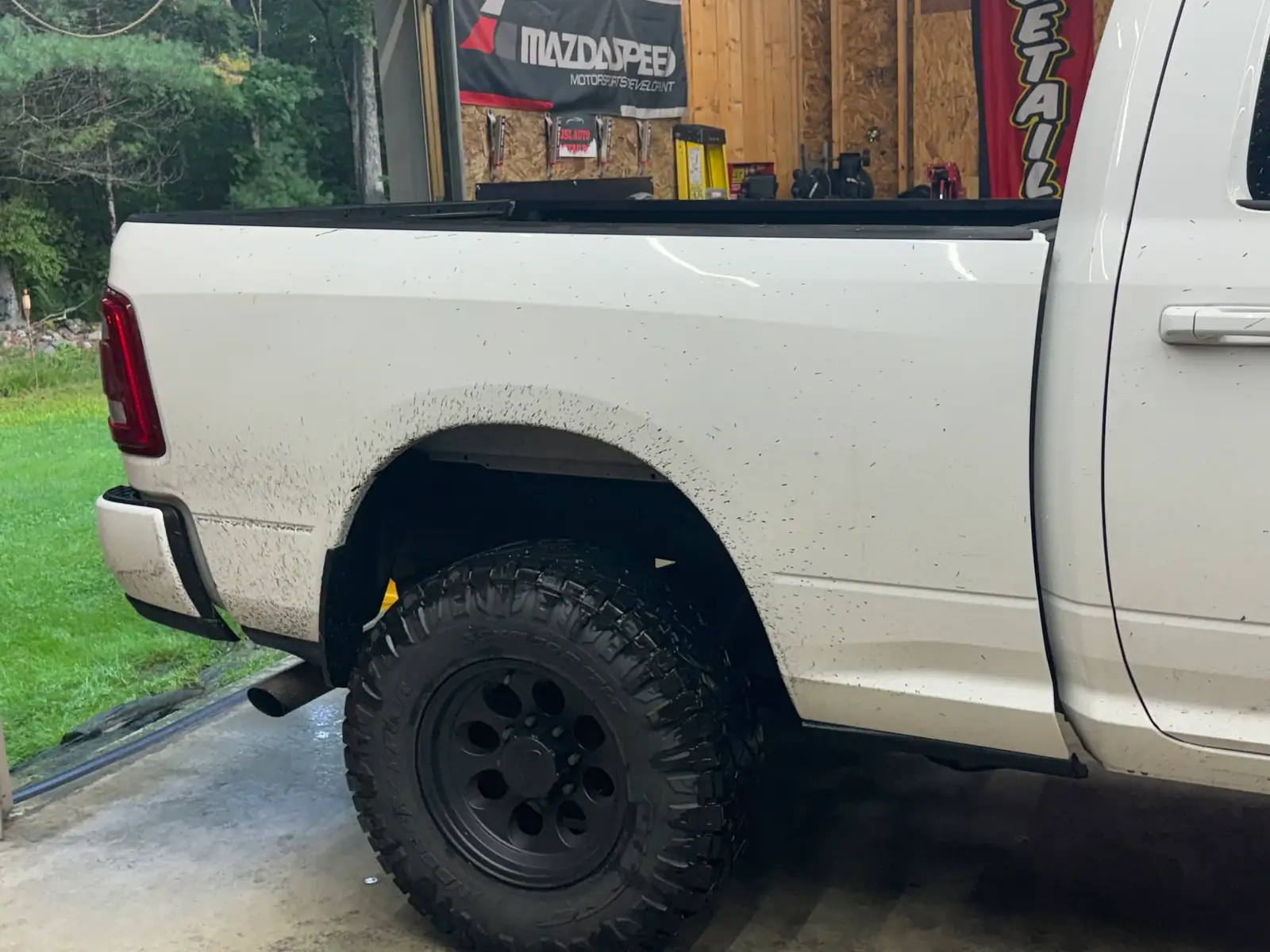 Mud along the white Ram's rear wheel and bed, before
