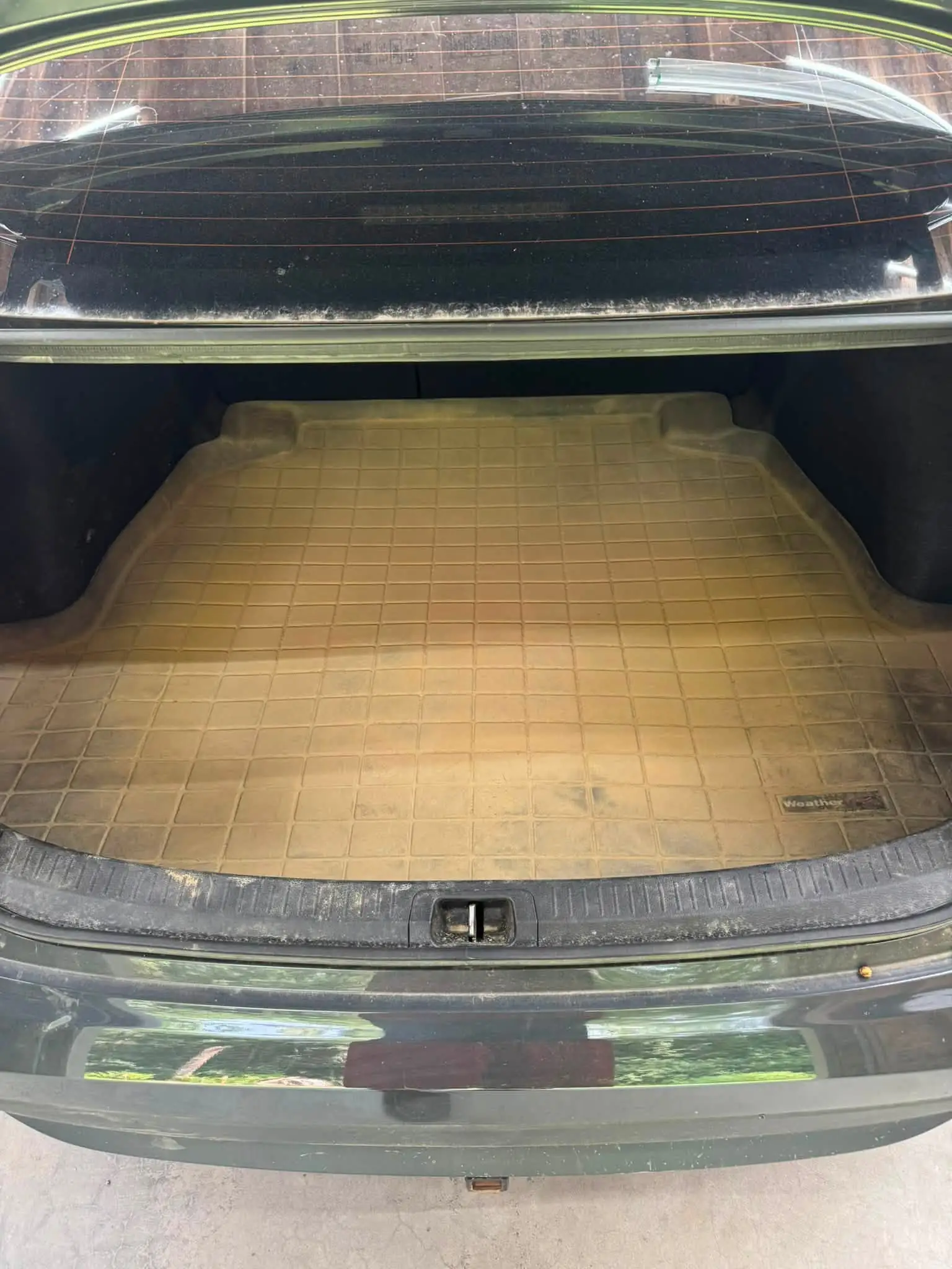 The same trunk liner covered in dust and dirt, before